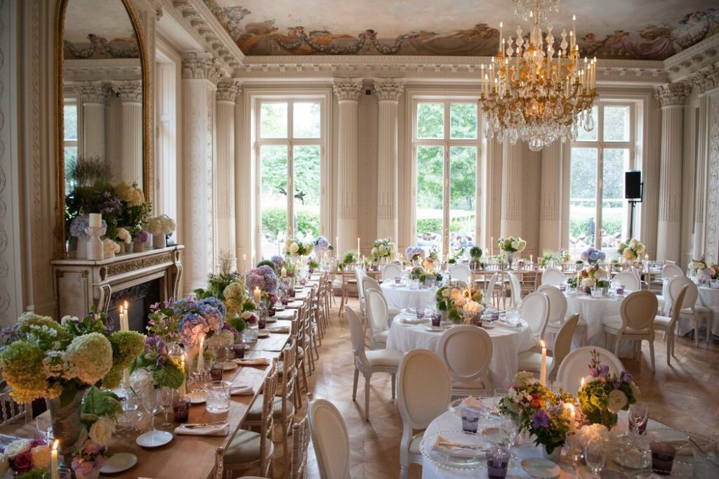 Salle de réception avec tables fleuries et lustre dans la galerie de Mariage dans l’Air