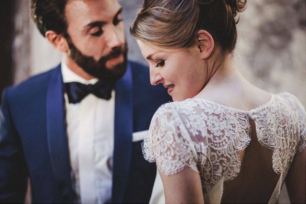 Portrait des mariés, robe au dos de dentelle et costume bleu