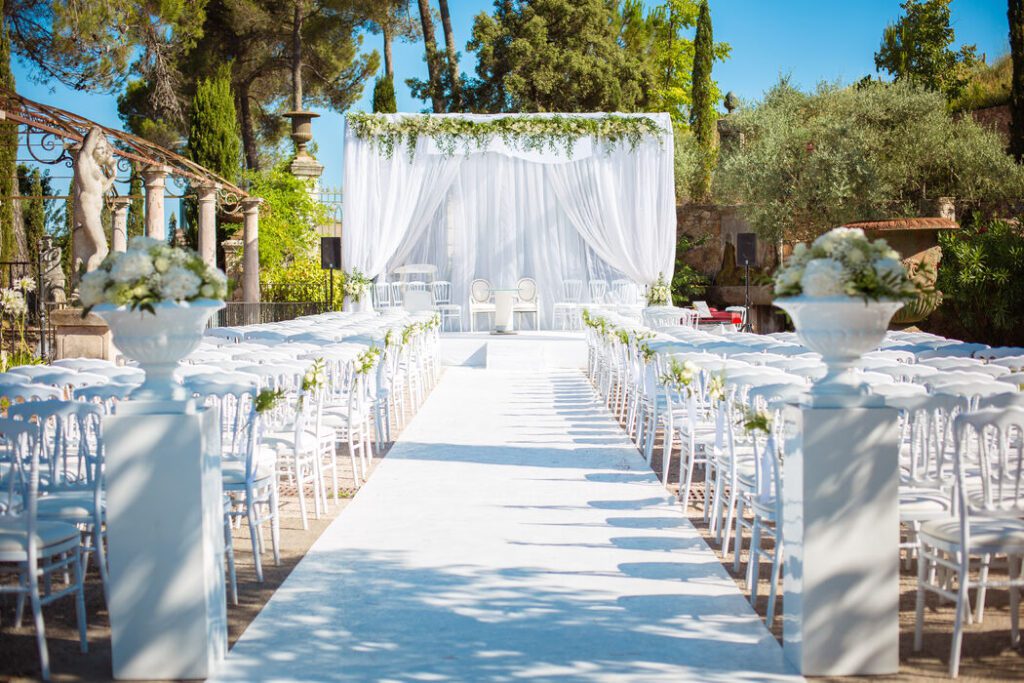 Allée de cérémonie avec dais et chaises blanches dans la galerie de Mariage dans l’Air