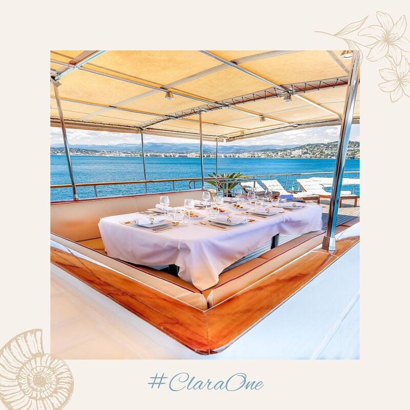 Table dressée sous le taud du Yacht Clara One, vue sur la mer