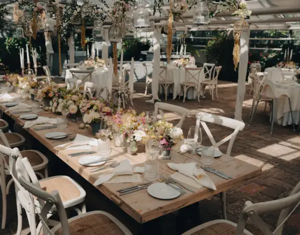 Décoration d'une salle de mariage avec tables dressées, fleurs et éclairage chaleureux