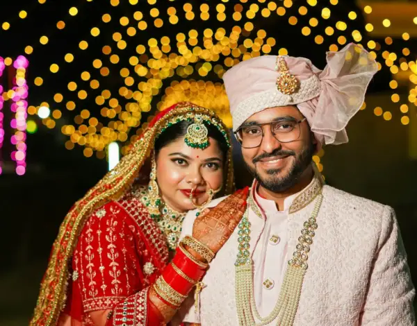 Couple en tenues de mariage indiennes sous des guirlandes lumineuses