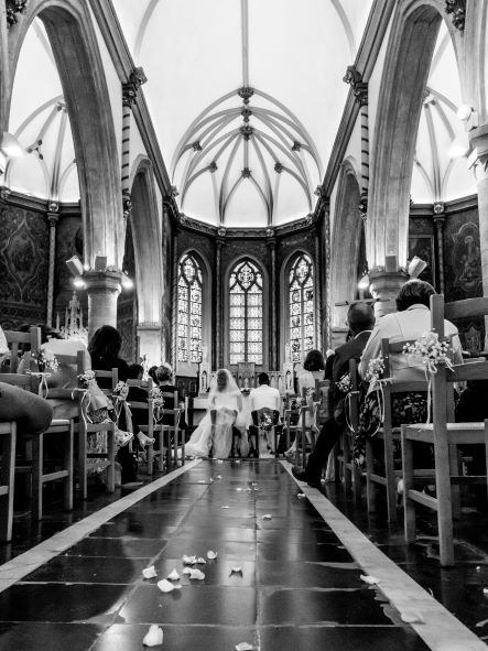Cérémonie de mariage dans une église, vue de l’allée centrale en noir et blanc