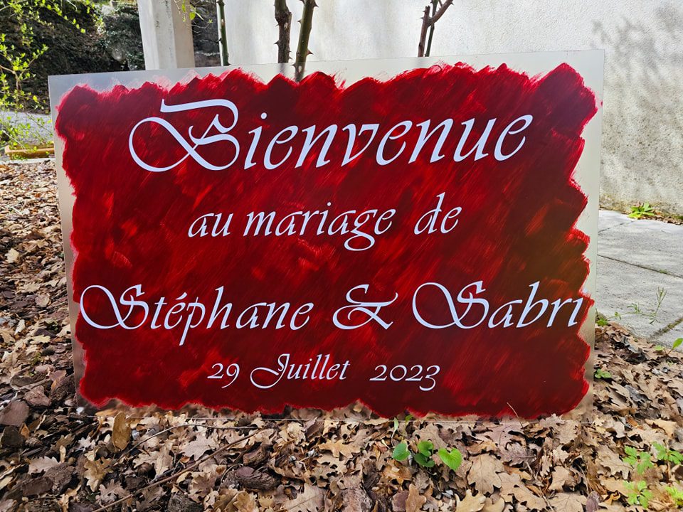 Panneau de bienvenue rouge avec lettrage blanc pour un mariage — 110 Créations