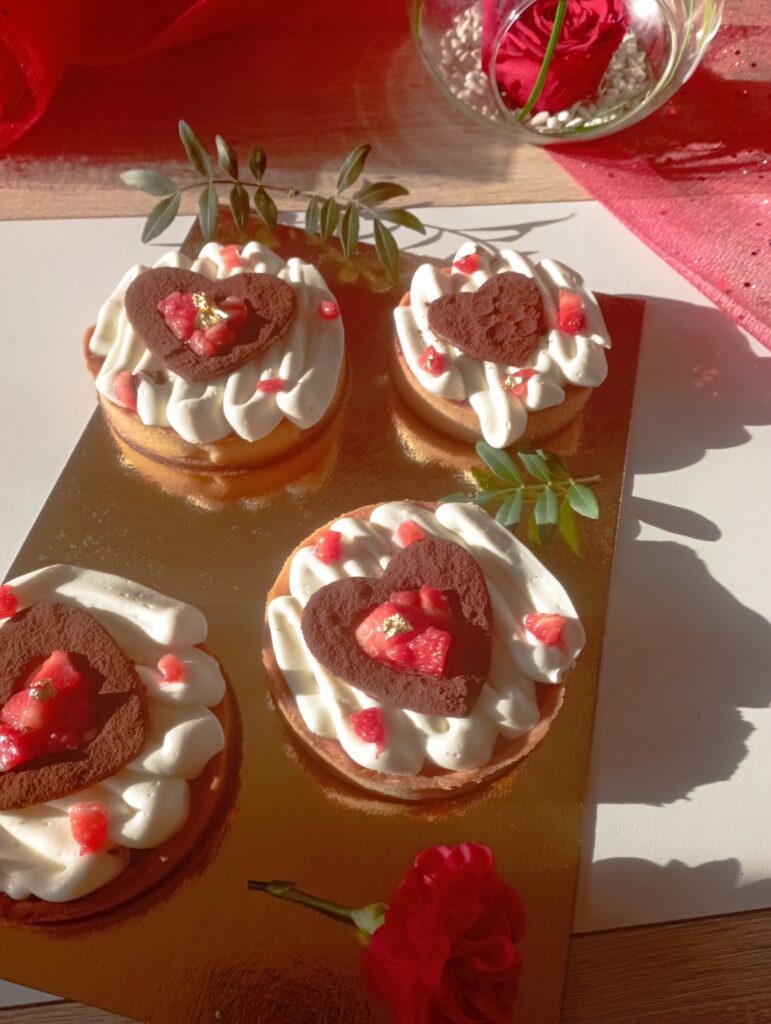 Petites pâtisseries à la crème, morceaux de fraises et décors en cœur