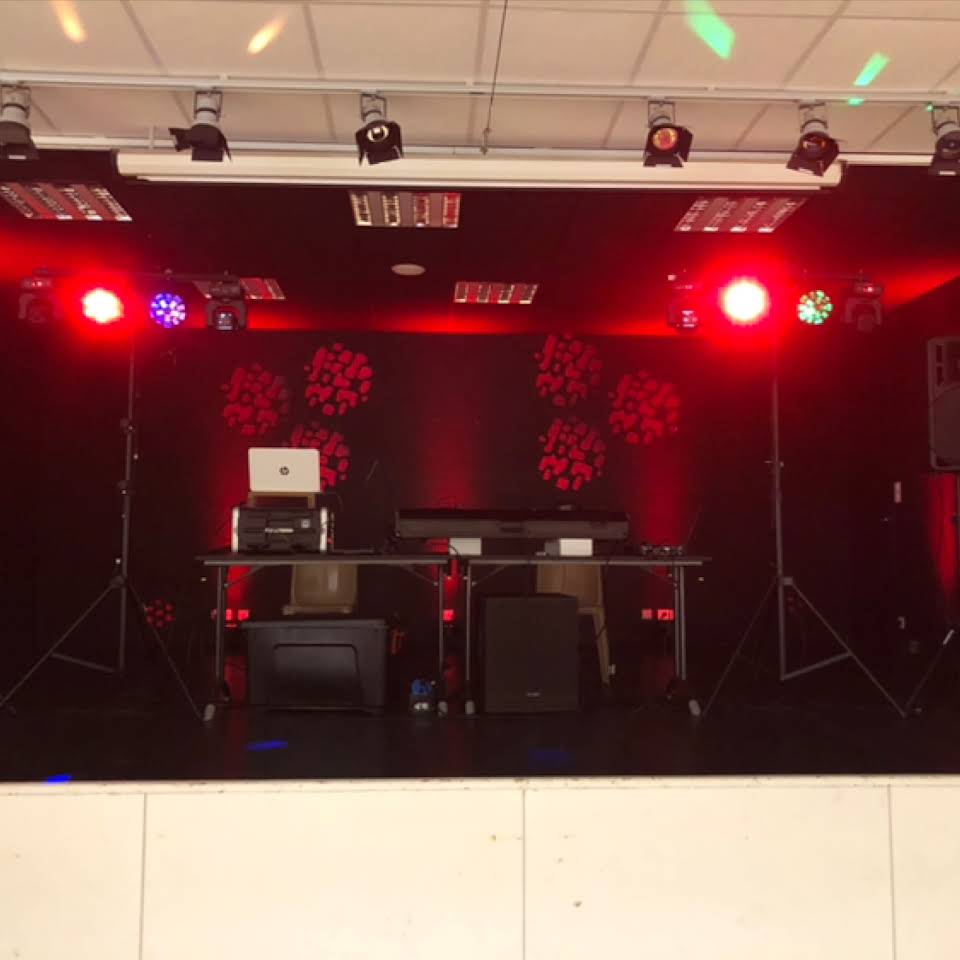 Installation DJ avec enceintes, ordinateur et projecteurs rouges