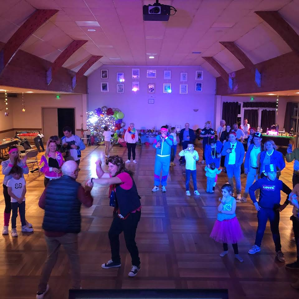 Participants sur une piste de danse éclairée en bleu et violet
