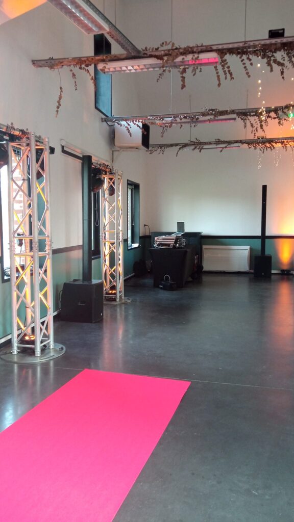 Enceintes et structures lumineuses près d’un poste DJ dans une salle