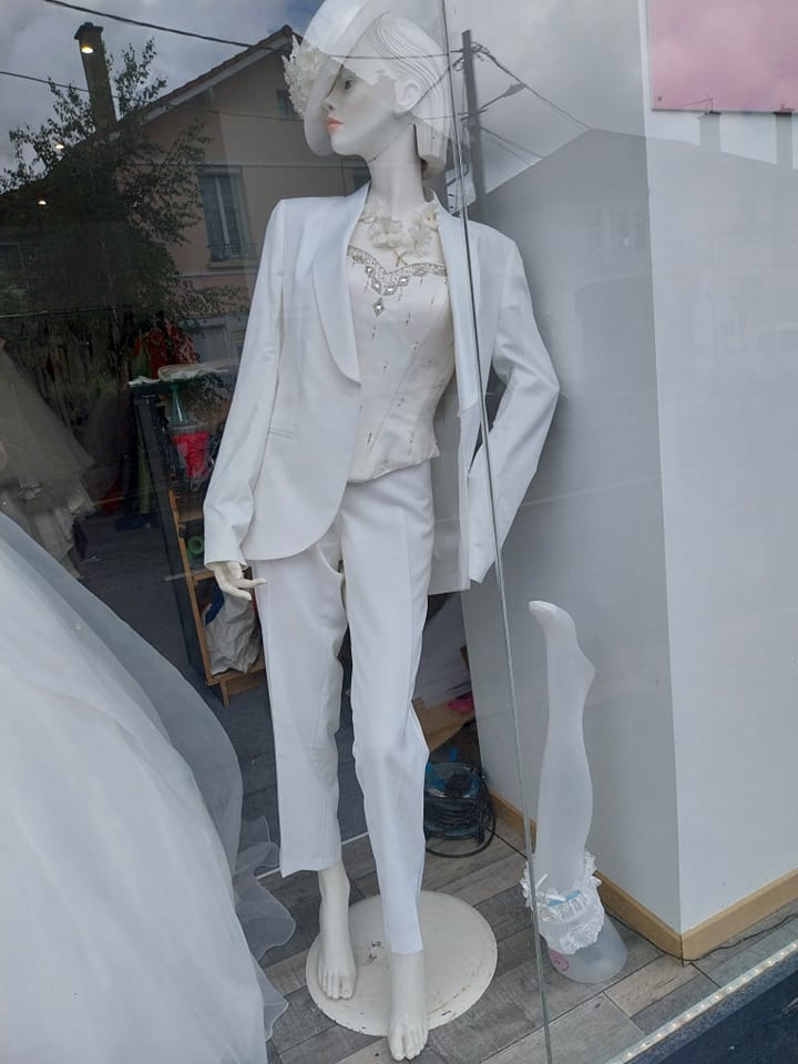 Tailleur pantalon blanc sur mannequin dans une vitrine
