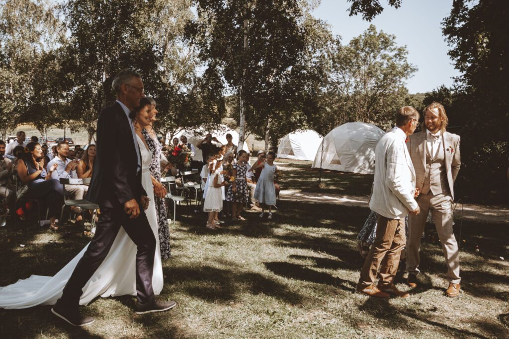 Arrivée de la mariée à une cérémonie en plein air parmi les invités