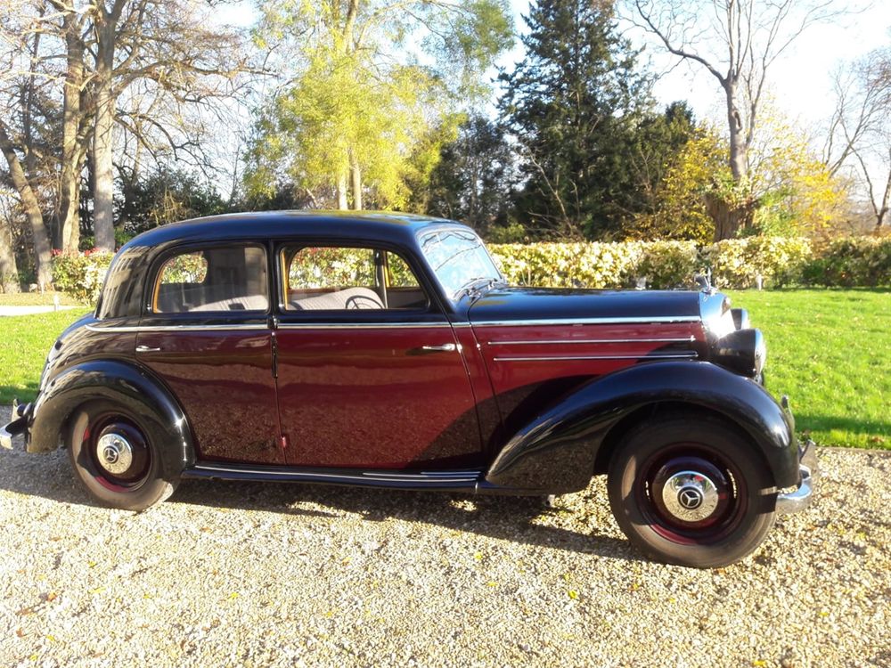 Voiture de collection bordeaux et noire photographiée de profil