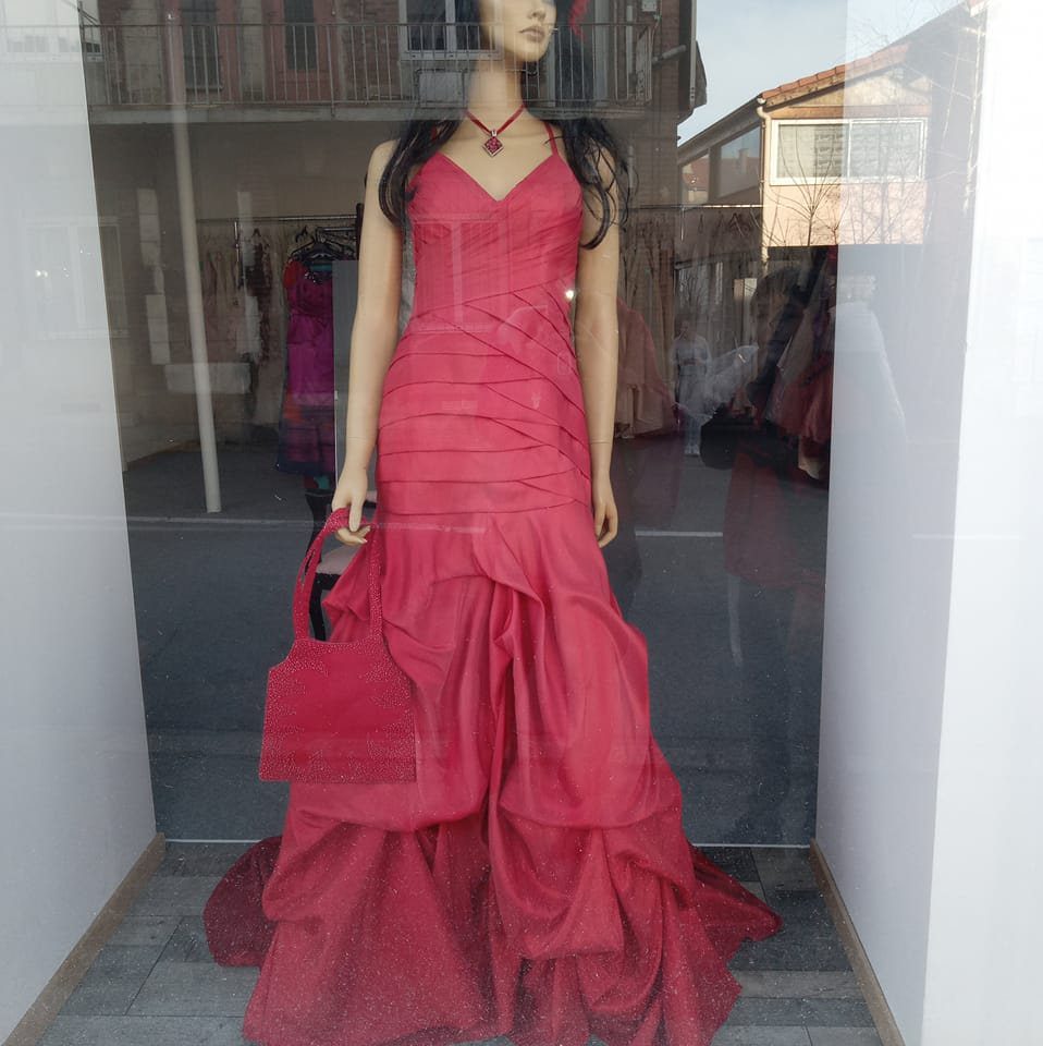Robe longue rouge sur mannequin dans une vitrine