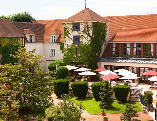 Jardin intérieur et terrasse avec parasols au Manoir de Gressy