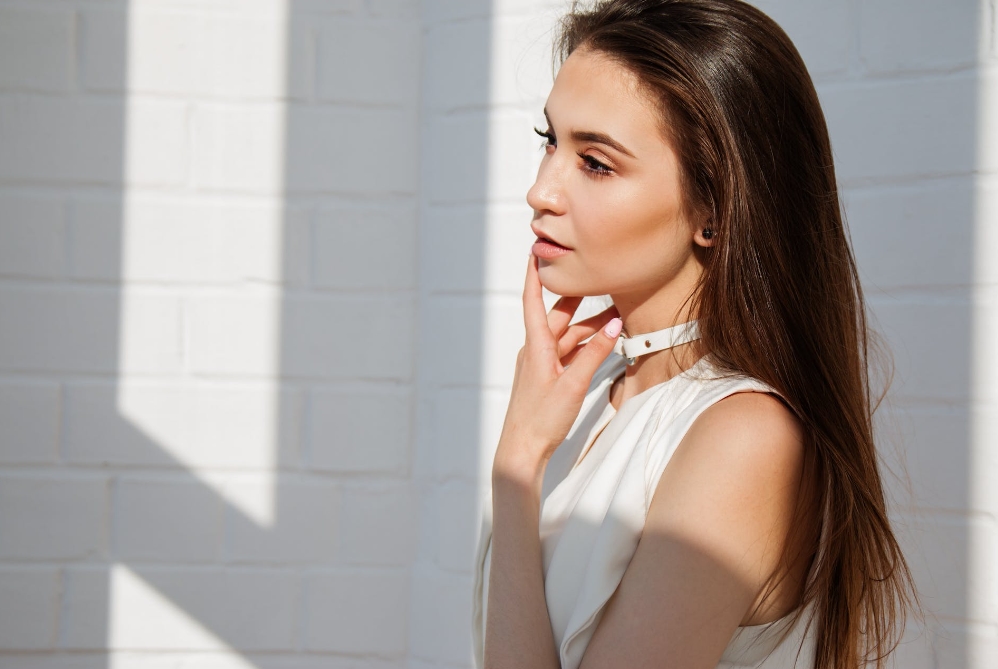 Portrait de profil d’une femme devant un mur blanc