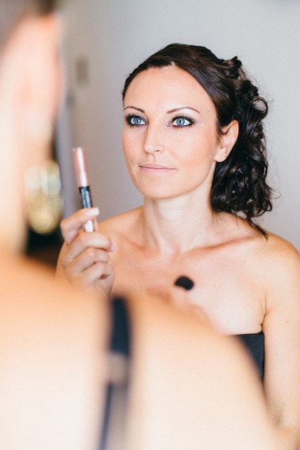 Femme tenant un applicateur de gloss devant un miroir — visuel de maquillage