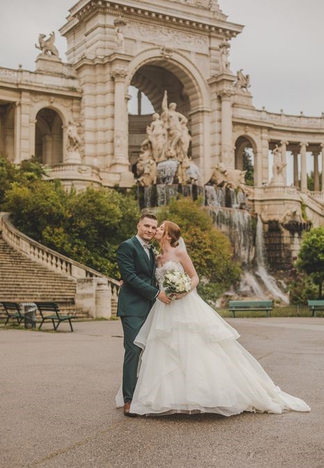 Mariés devant une fontaine et une arche monumentale