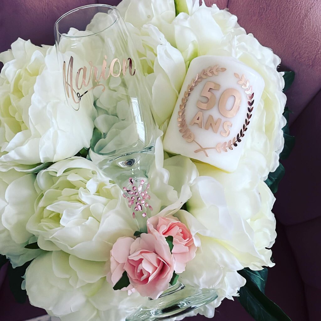 Verre personnalisé et bougie d’anniversaire parmi des fleurs blanches — Miss Majestic