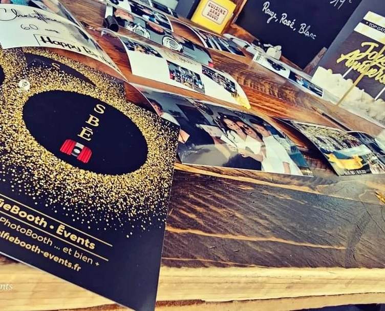 Tirages photo disposés sur une table avec une brochure SelfieBooth Events