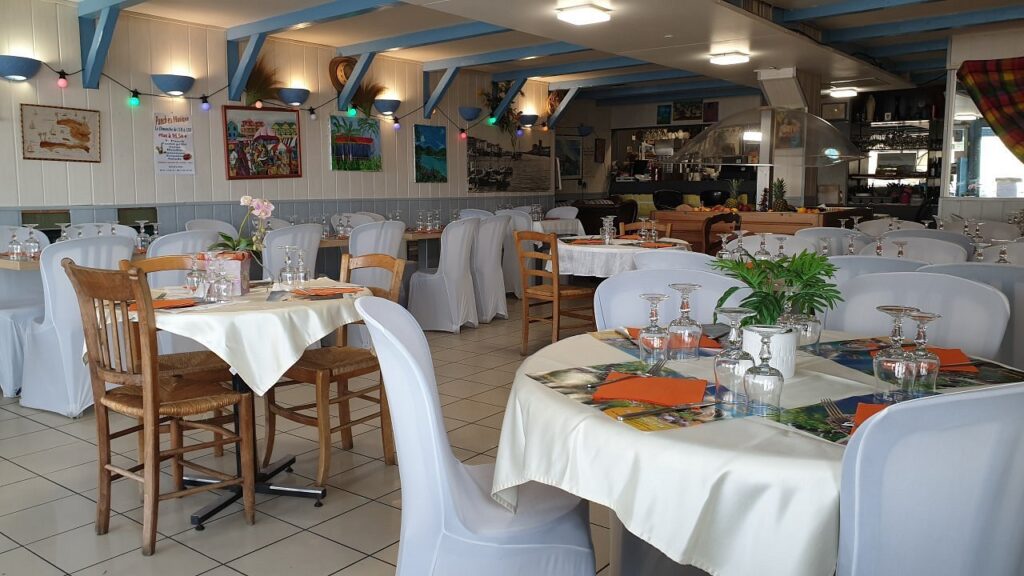 Salle du Nautique avec tables dressées et chaises en bois