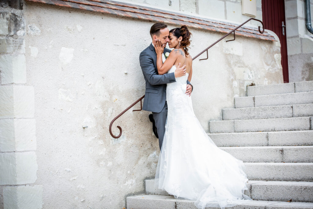 Couple de mariés enlacé sur un escalier extérieur