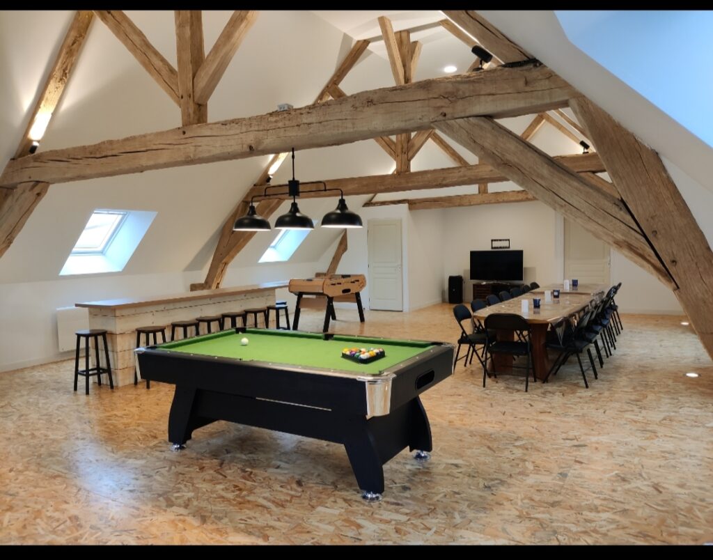 Salle sous charpente avec billard, baby-foot et grande table