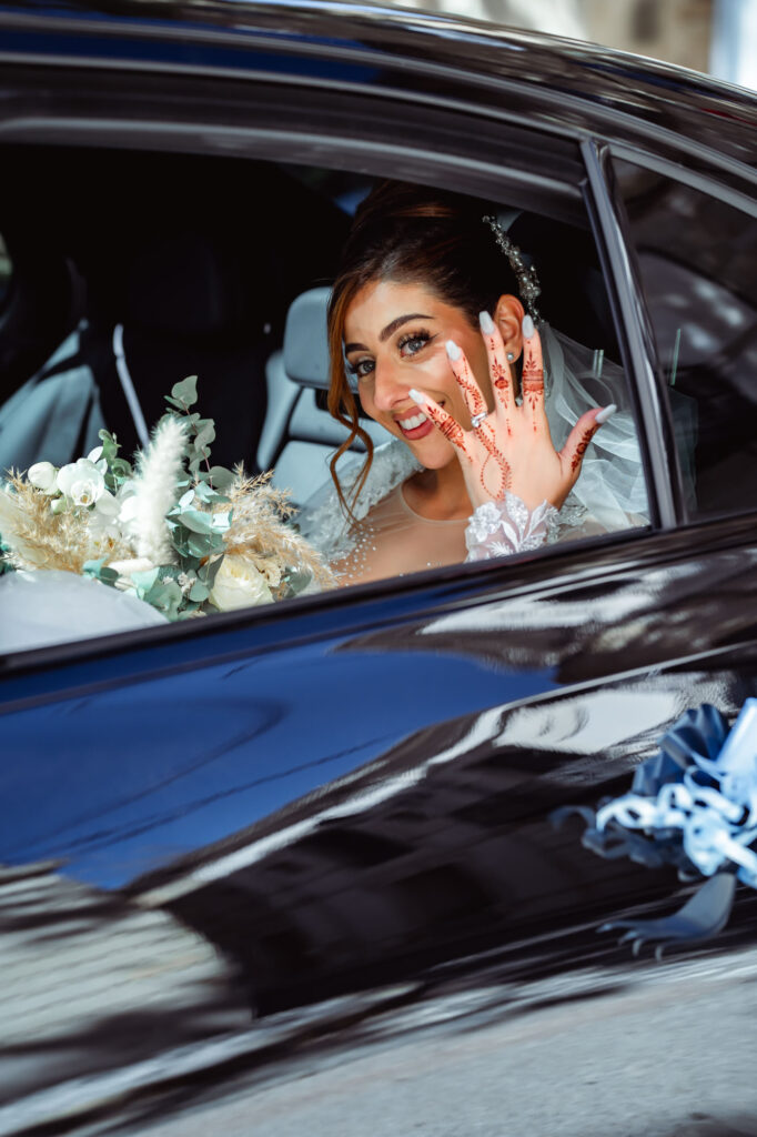 Mariée dans une voiture, bouquet et main décorée au henné — Jim Mariage