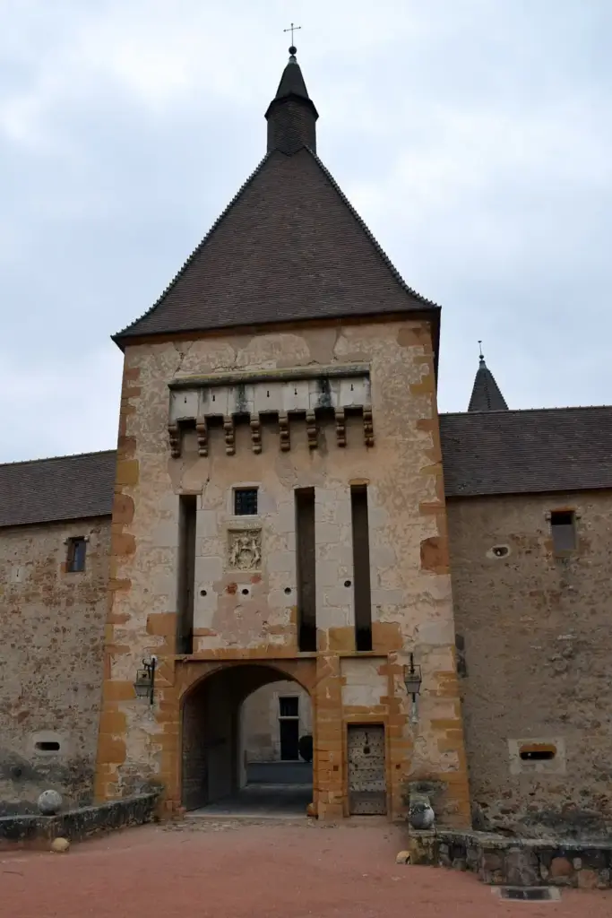 Fortified gateway of Château de Corcelles-en-Beaujolais beneath a tall tower