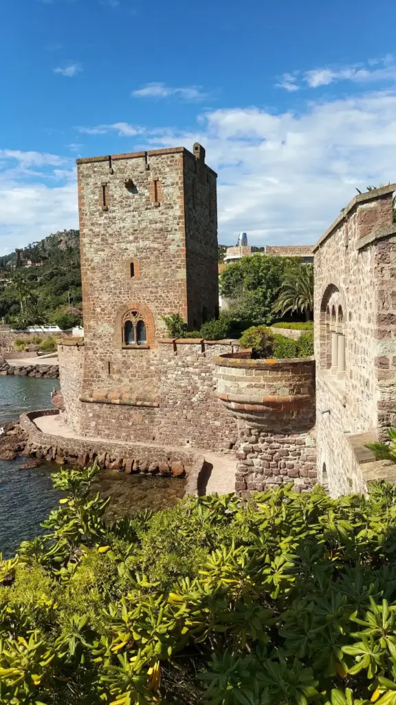Crenellated tower and walls of Château de La Napoule above a garden