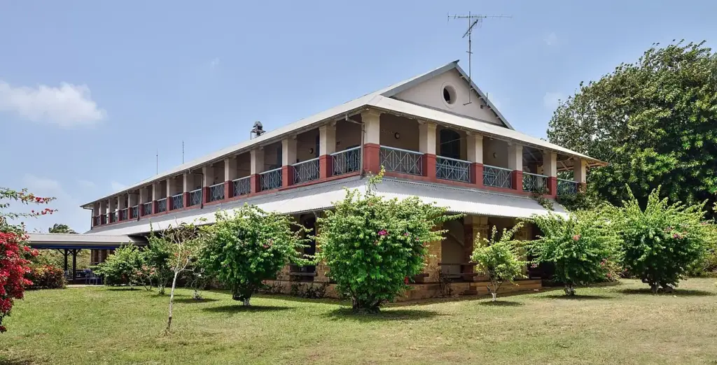 Façade jaune de l’Hostellerie des Îles du Salut sur l’Île Royale
