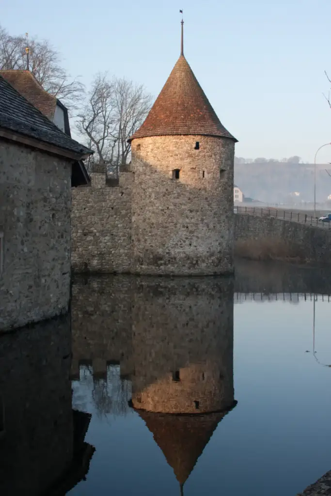 Round tower of Château de Hallwyl and its reflection in the moat