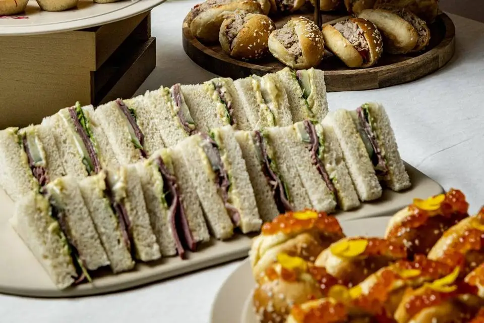 Plateau de mini-sandwichs et de bouchées sur un buffet de Riv’K Traiteur