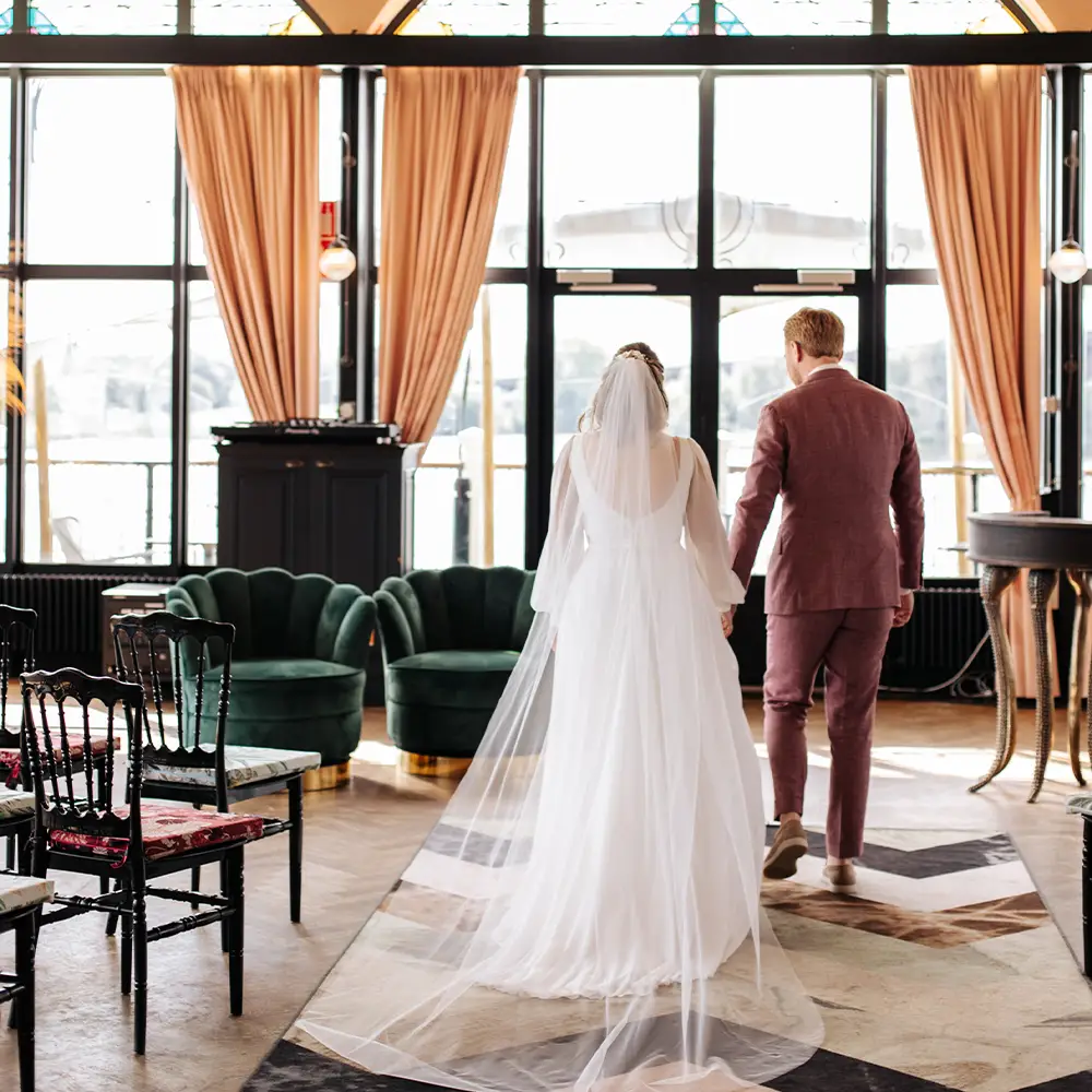Bruidspaar in de trouwzaal van het Zalmhuis met uitzicht op het water