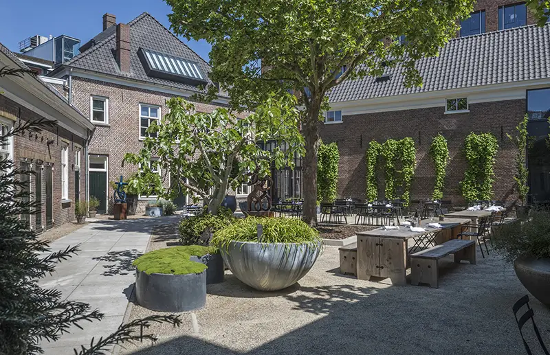 De groene binnentuin en het terras van Kazerne Eindhoven