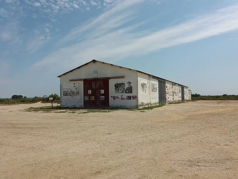 Façade d’un bâtiment du Domaine de Méjanes avec portes rouges