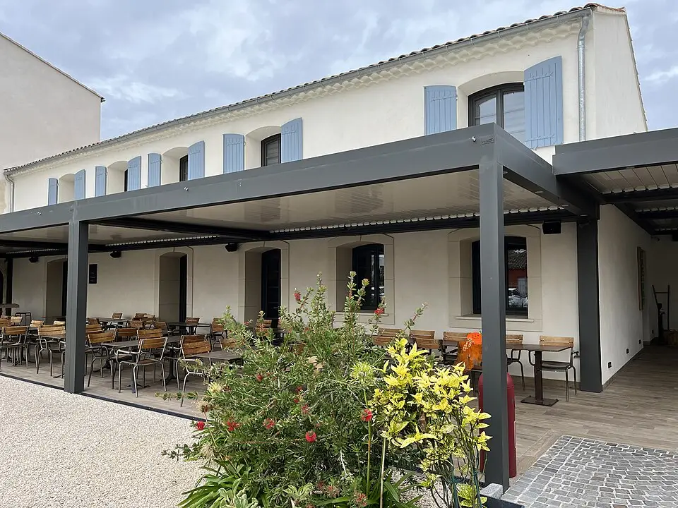 Factory restaurant terrace at Hôtel 1770 in Le Pontet, beside a façade with blue shutters