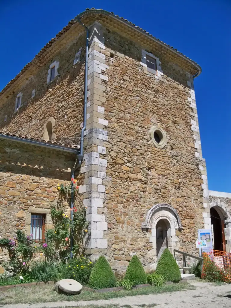 Façade en pierre de l’église de Valsaintes, avec portail arrondi et oculus