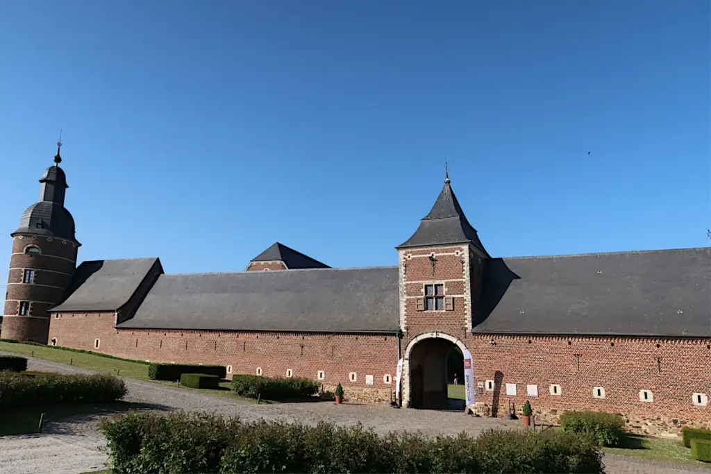 Façade extérieure en briques de La Ramée, avec tour et porche encadré de pierre
