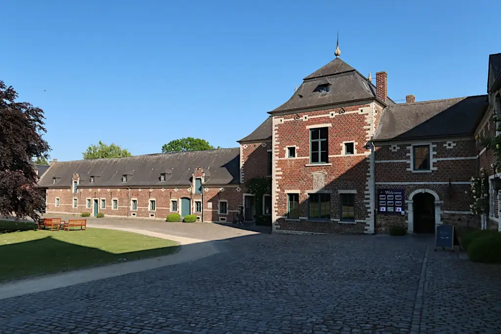Cour pavée de La Ramée et bâtiment en briques à haute tour carrée
