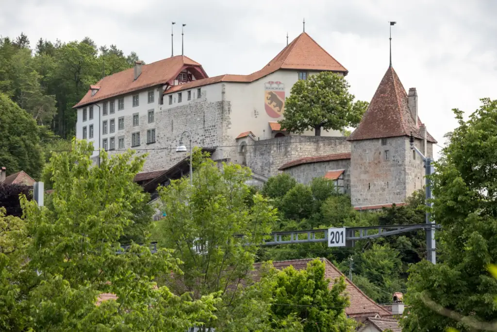 Schloss Laupen with stone façades, red roofs and the Bern coat of arms, viewed from the west