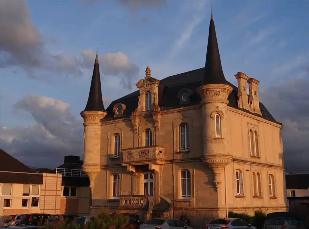 Villa Les Tourelles à Asnelles, avec deux tours à toits pointus et balcon en pierre