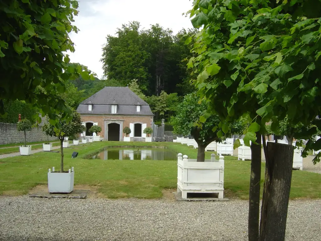 Orangerie de Freÿr au fond du jardin avec bassin et orangers en caisse