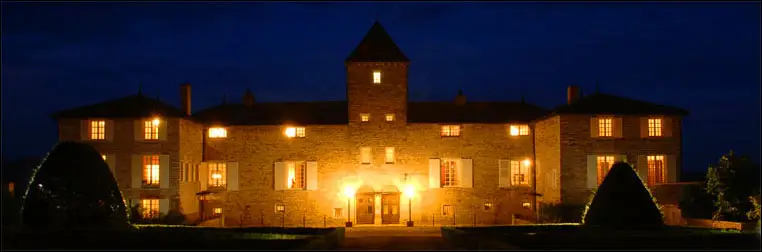 Illuminated façade of Château de Besseuil at nightfall
