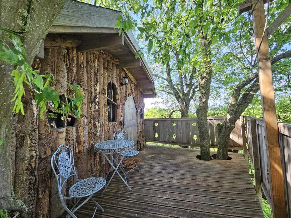 Cabane en bois et terrasse parmi les arbres au Refuge des 3 Ours