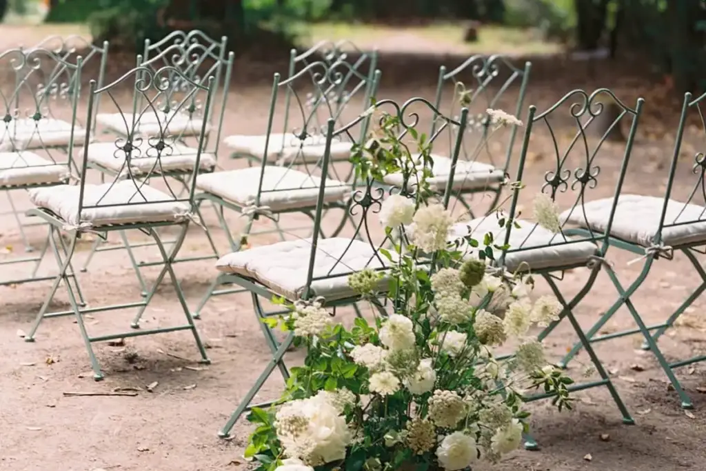 Chairs and floral arrangements for a garden ceremony at Casa dos Penedos