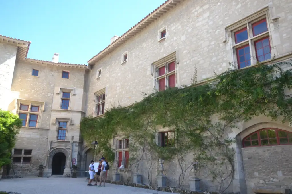 Façades en pierre et végétation dans la cour d’honneur du Château de Thézan