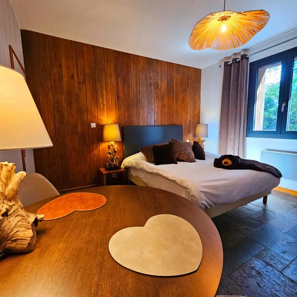 Chambre d’hôtes avec lit double et décoration bois au Refuge des 3 Ours