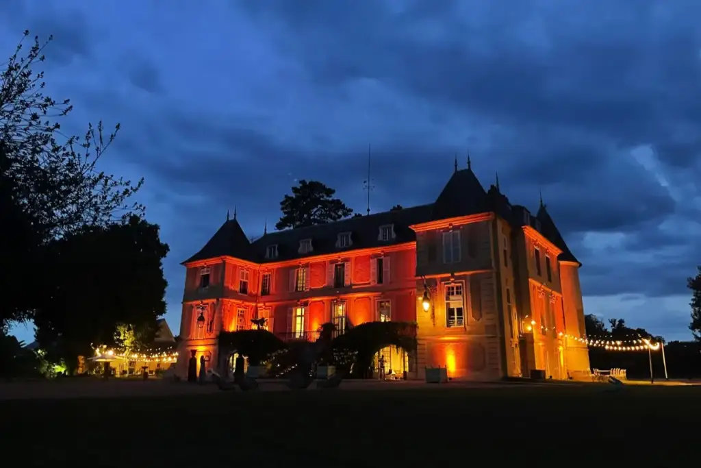 Façade éclairée du Château de Vaugrigneuse lors d'une soirée de mariage au domaine