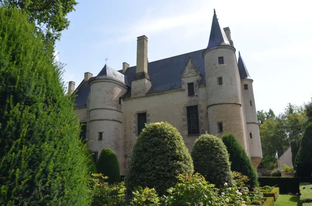 Façade nord et tours du château de Hac au-dessus des arbustes taillés du jardin