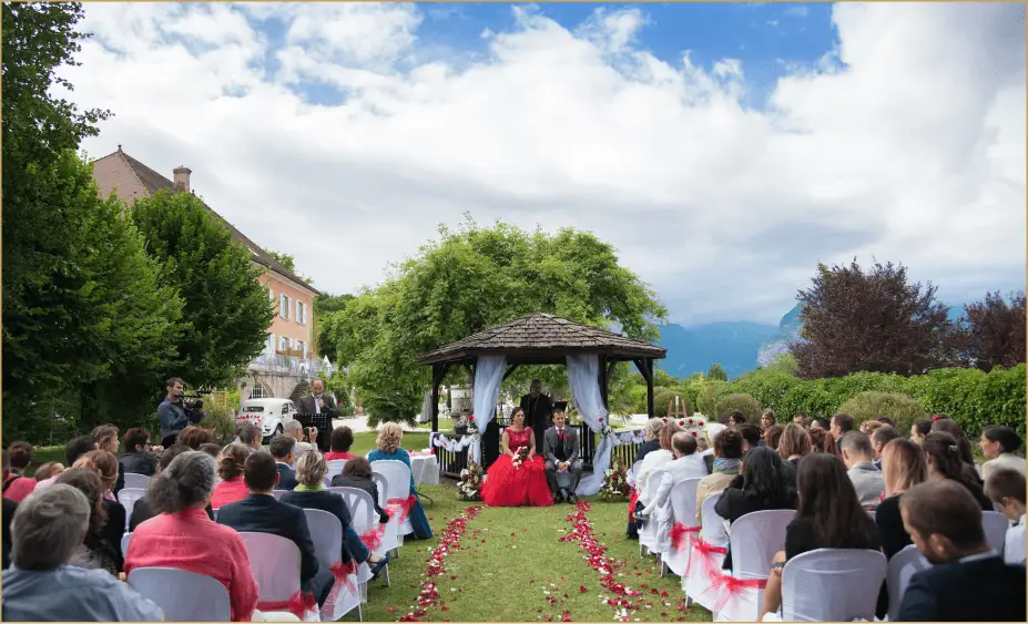 Cérémonie de mariage dans le jardin du Château de la Baume avec un kiosque et les montagnes en arrière-plan