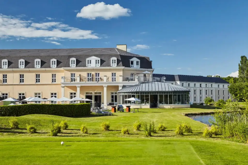 Façade du Mercure Chantilly et sa terrasse vitrée vues depuis la pelouse du golf